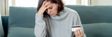 Stressed woman holding credit card