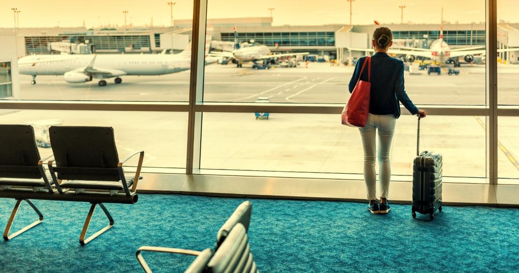 Woman standing in an airport with luggage