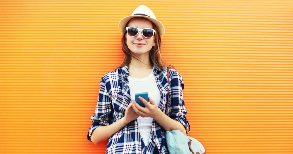 woman holding phone checking money app