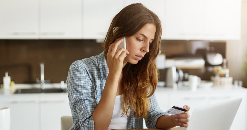 Woman on the phone looking at her credit card
