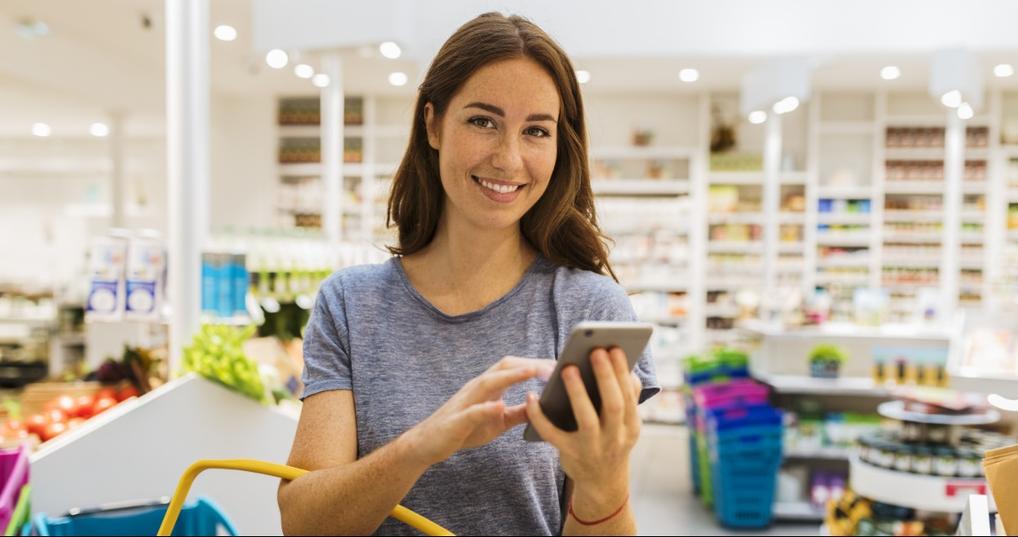 Woman smiling at phone while shopping