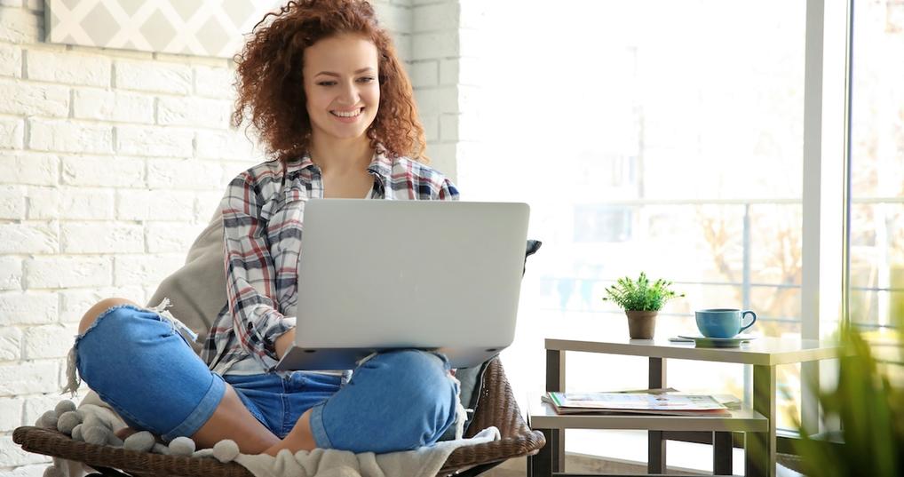 Happy woman at home with laptop