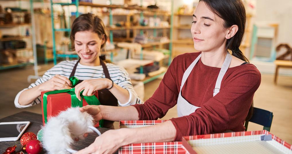 Women wrapping gifts in store