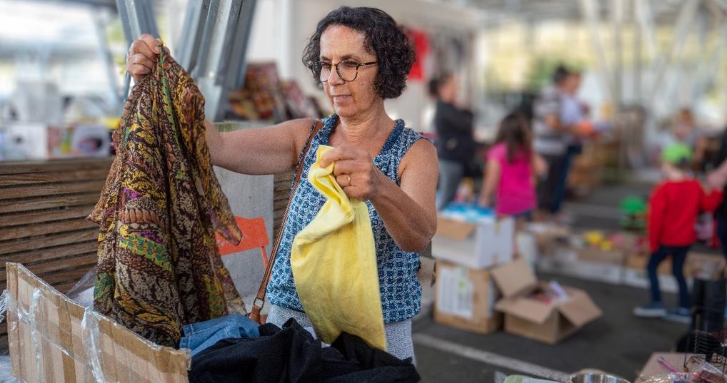 woman choosing clothes at garage sale