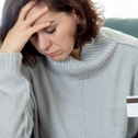 Stressed woman holding credit card