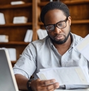 Man looking at papers and computer