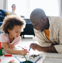 Father and child coloring together