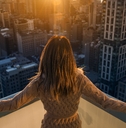Rich woman enjoying the sunset standing on the balcony of a luxury apartments in New York City