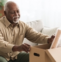 retired senior man packing stuff in box indoors