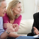 mature couple sitting on sofa with financial advisor