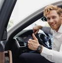 smiling man getting out of the car with a thumbs up
