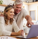 An older couple looking at computer
