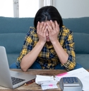 Stressed woman will bills and computer