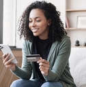Woman holding her phone in one hand and credit card in the other