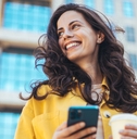 Smiling woman holding a phone and coffee
