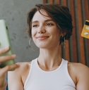 Woman holding a phone in one hand and a credit card in the other