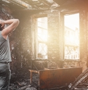 Man standing inside burnt house