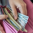 Woman taking out dollar from wallet