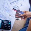 stressed man choosing card to pay bills