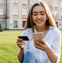 A woman holds her credit card and iPhone. 