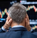A distressed businessman observing volatile stock market trends