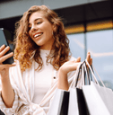 person looking at phone holding shopping bags