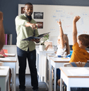 Teacher with students with hands raised
