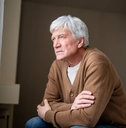 Senior man sits staring blankly out window
