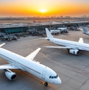 Airplanes parked on tarmac during sunset
