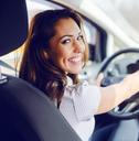 Woman in driver's seat smiling