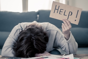 stressed woman holding up help sign