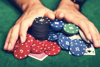 Person pushing poker chips at table