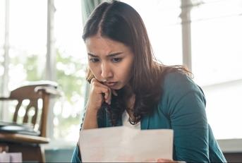 Worried woman looking at paperwork