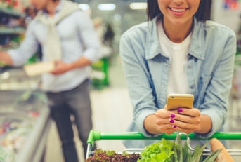 Woman using phone at grocery store