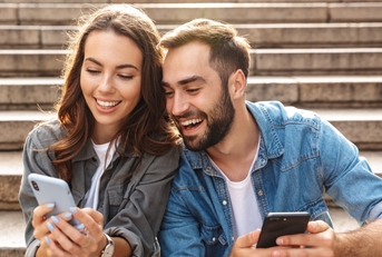 Happy couple looking at phones