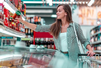 beautiful woman with shopping cart at supermarket