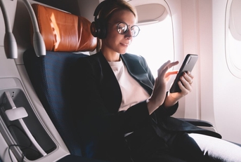 Woman sitting in business class using phone