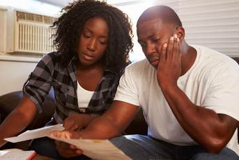 Stressed couple looking at paperwork