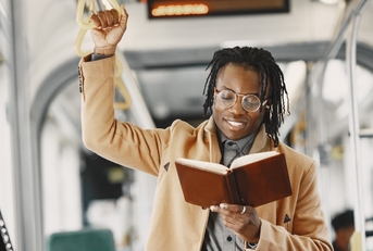 man reading book on train