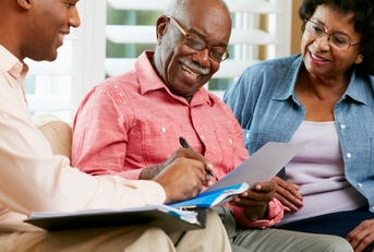 Senior couple reviewing documents with a salesperson