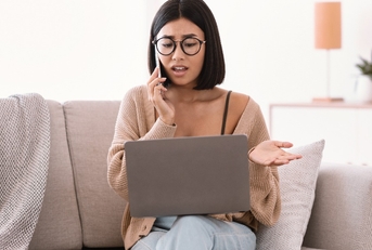 woman talking on mobile phone sitting on sofa