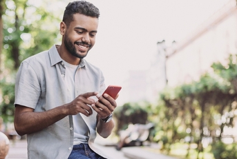 Man smiling and looking at phone