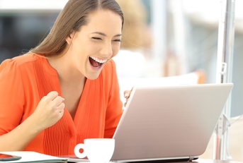 Woman cheering at computer screen