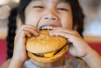 Happy girl eating a burger