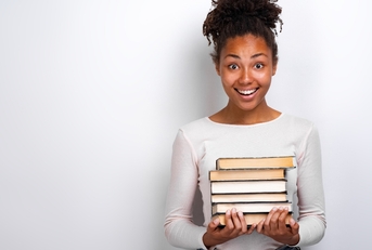 Young African American woman holding a stack of books 