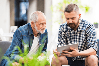 Father and son talking and looking at tablet
