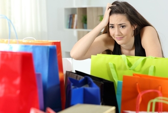 worried shopaholic woman after multiple purchases 