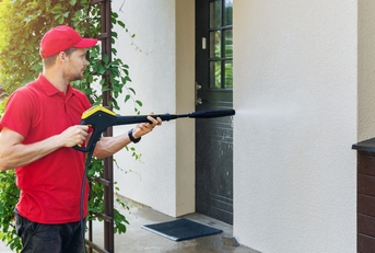 Man pressure washing a building