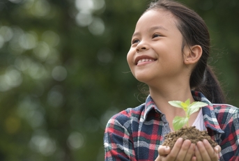 Asian child holding a plant