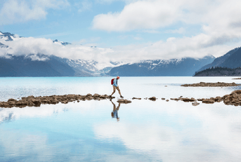 Person walking on stones in lake